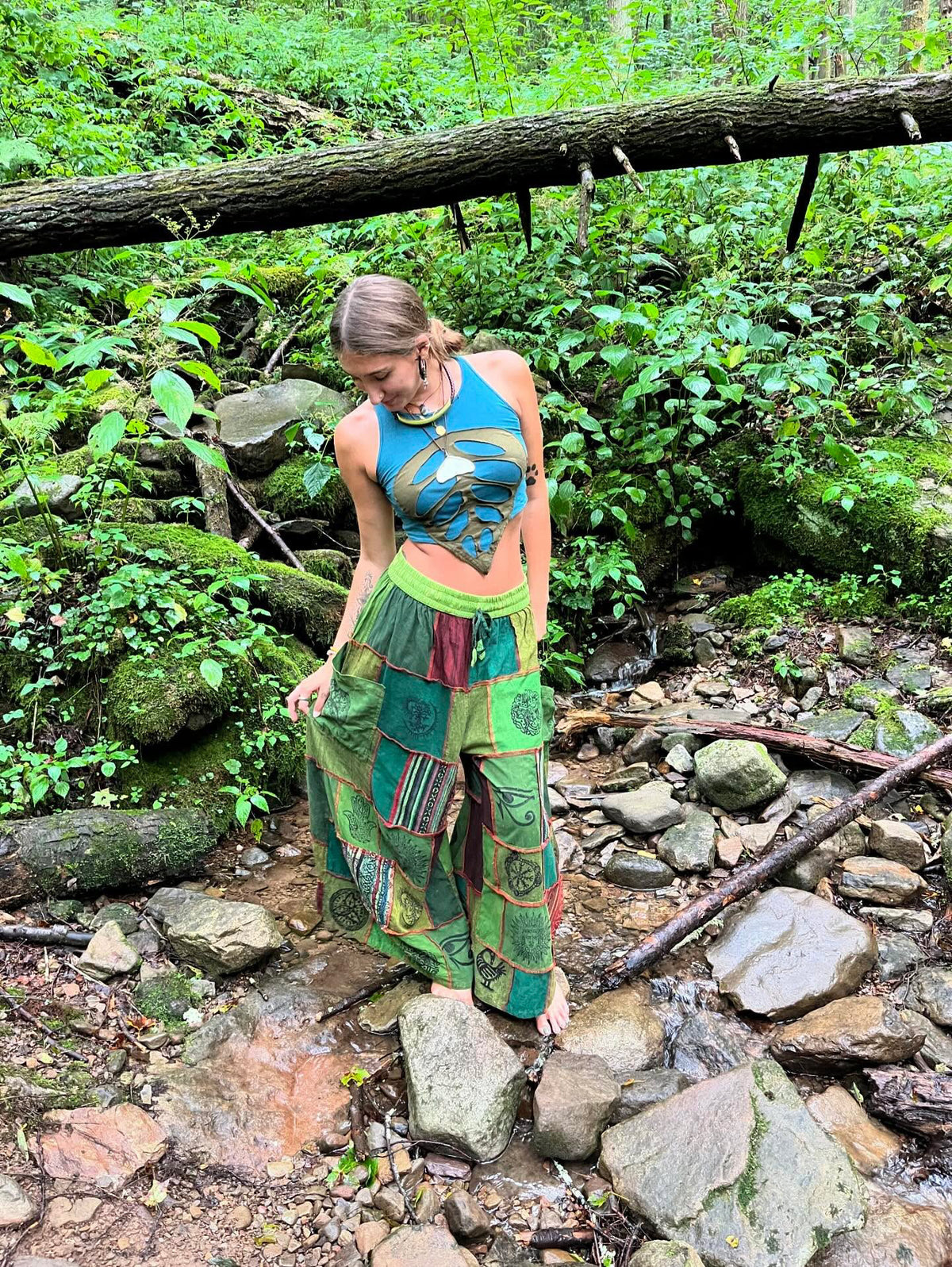 Model wearing handmade boho harem patchwork pants in an outdoor setting