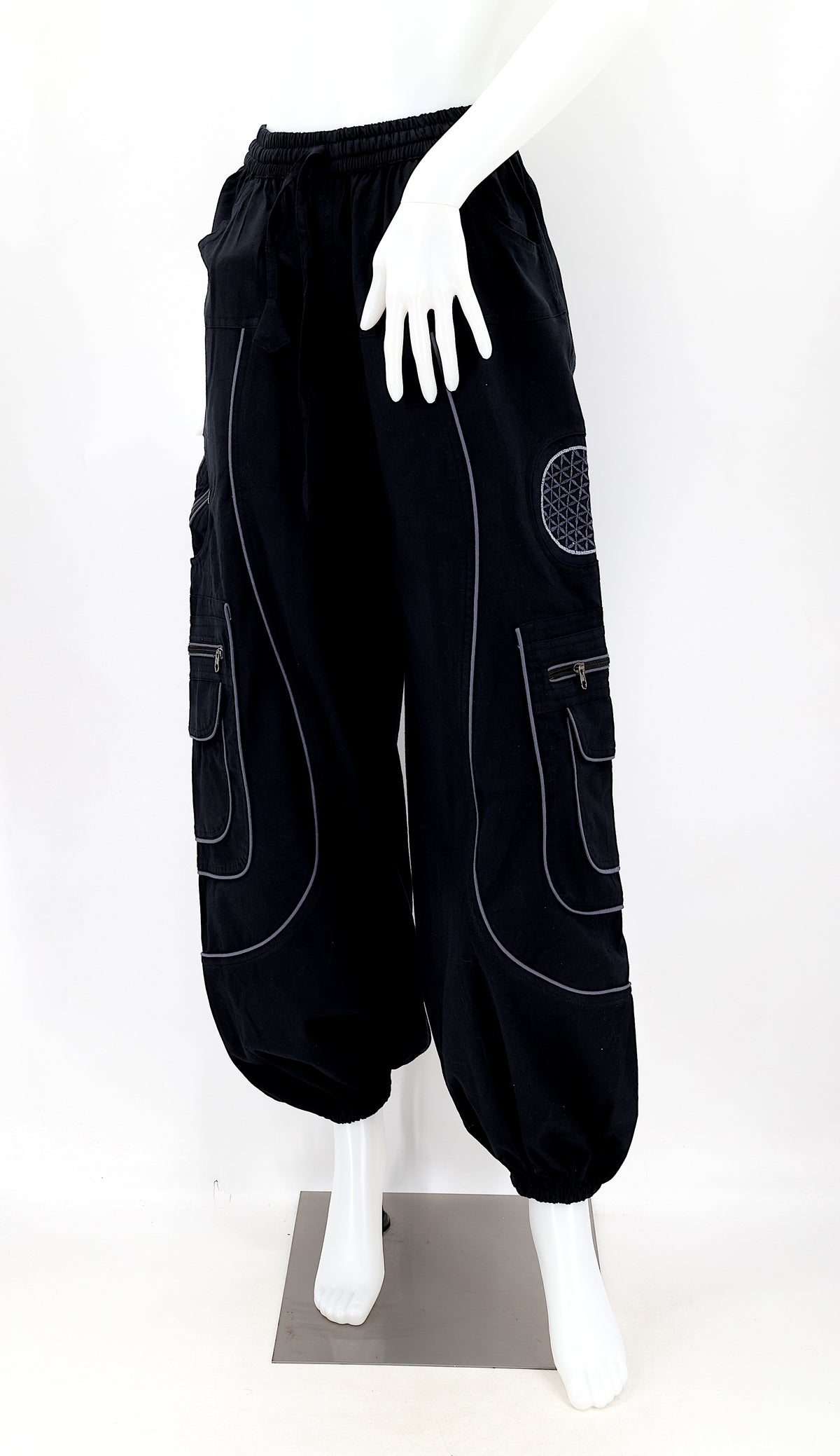 Close-up of black embroidered Flower of Life symbol on handmade trousers