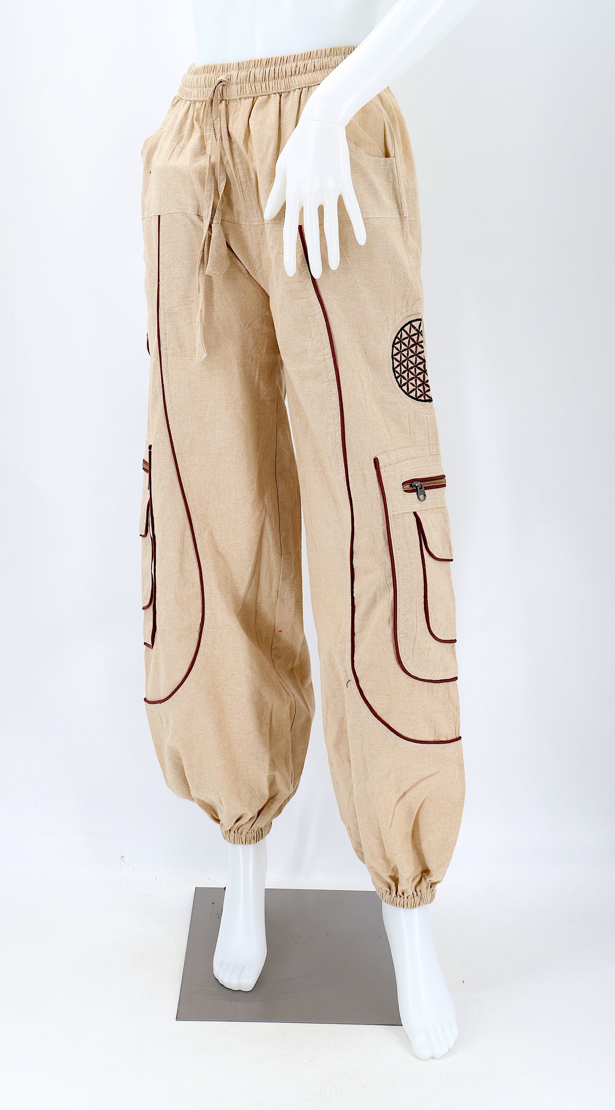 Close-up of beige embroidered Flower of Life symbol on handmade trousers