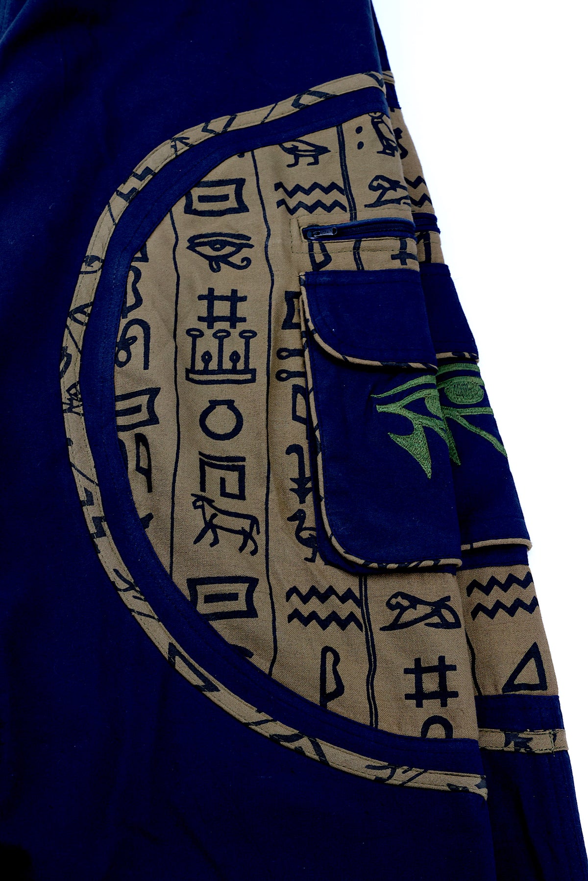 Close-up of intricate Eye of Ra embroidery on natural cotton fabric.
