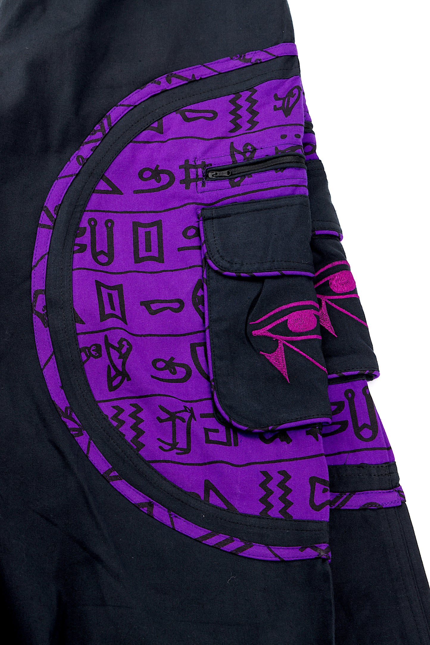 Close-up of intricate Eye of Ra embroidery on natural cotton fabric.