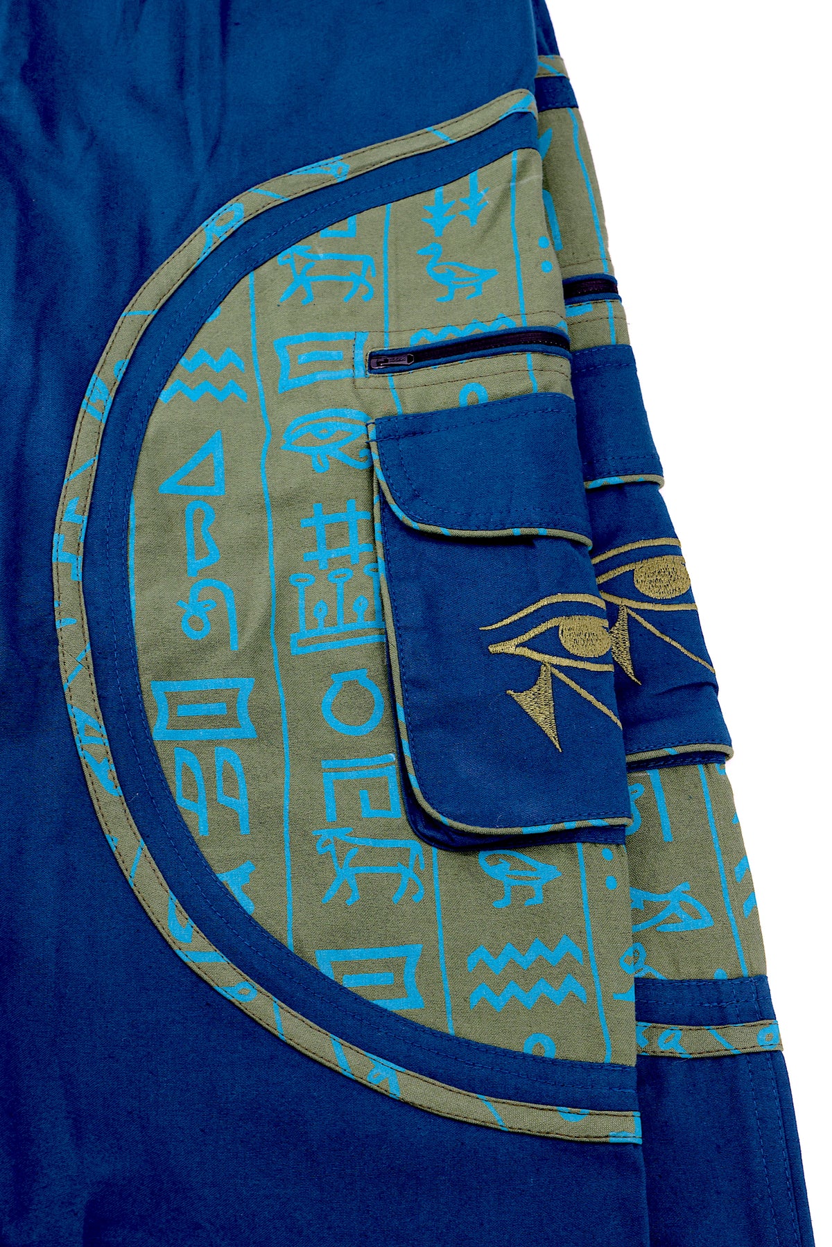 Close-up of intricate Eye of Ra embroidery on natural cotton fabric.