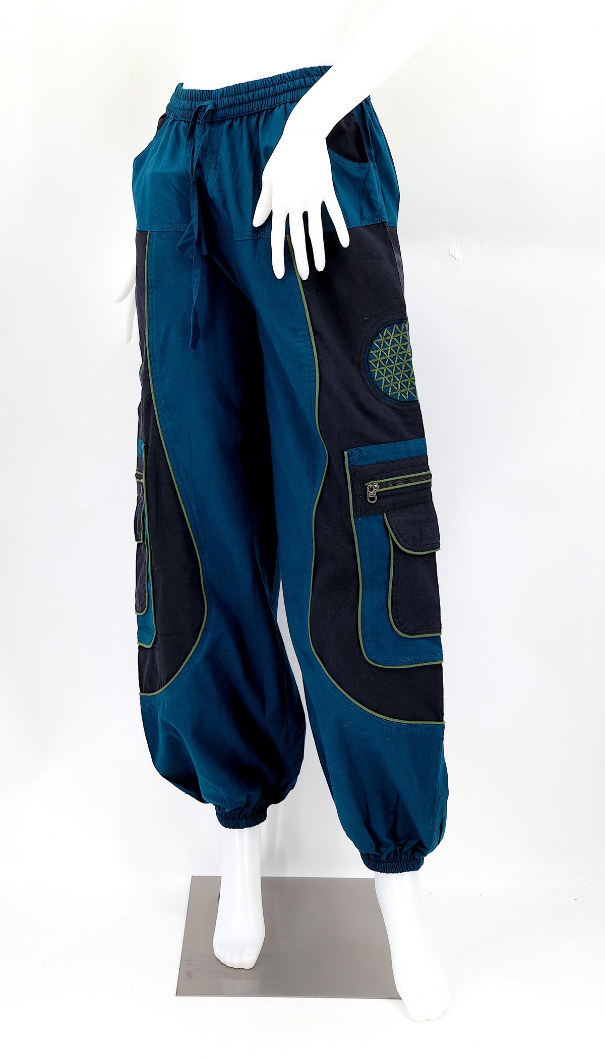 Close-up of teal blue embroidered Flower of Life symbol on handmade trousers