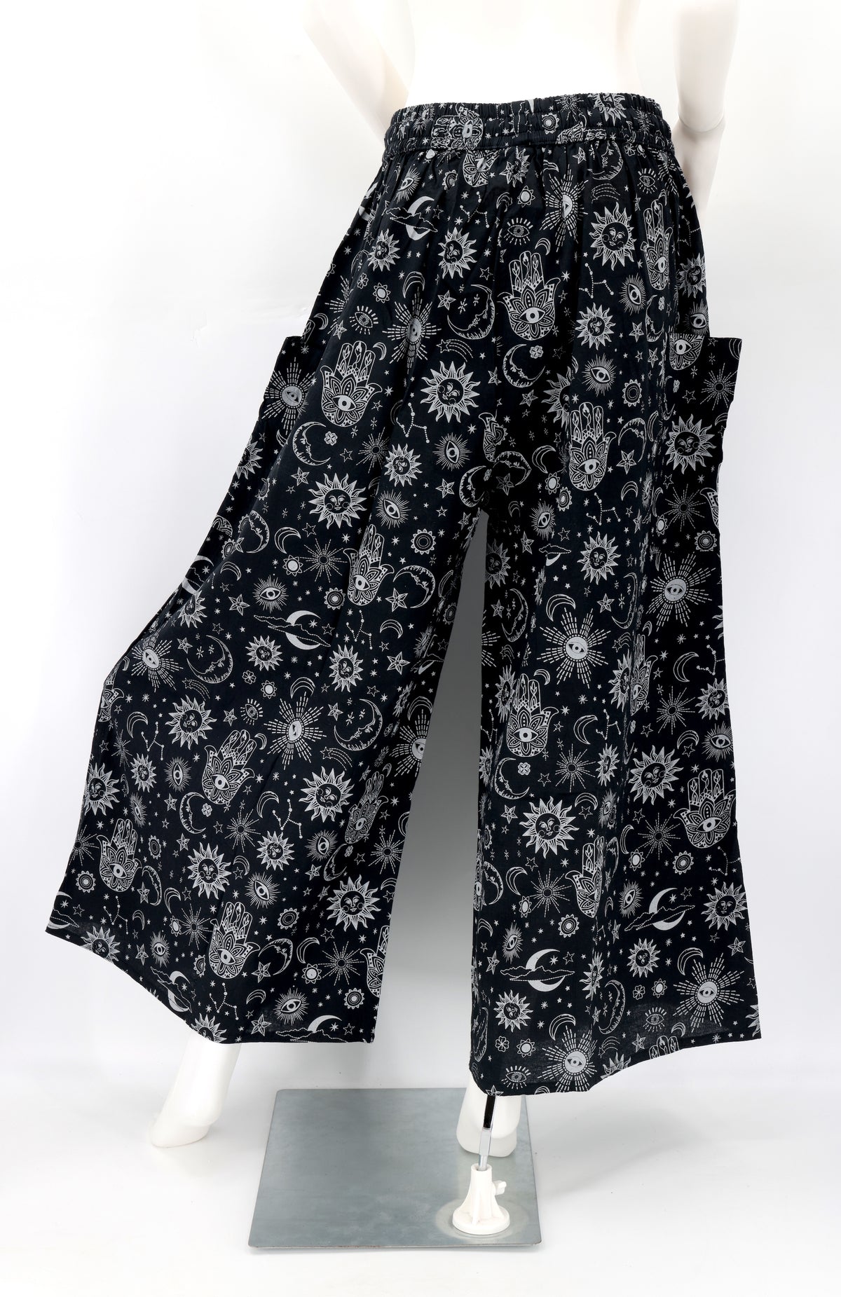 Back angle of wide-leg harem pants with celestial designs and flowy cotton fabric