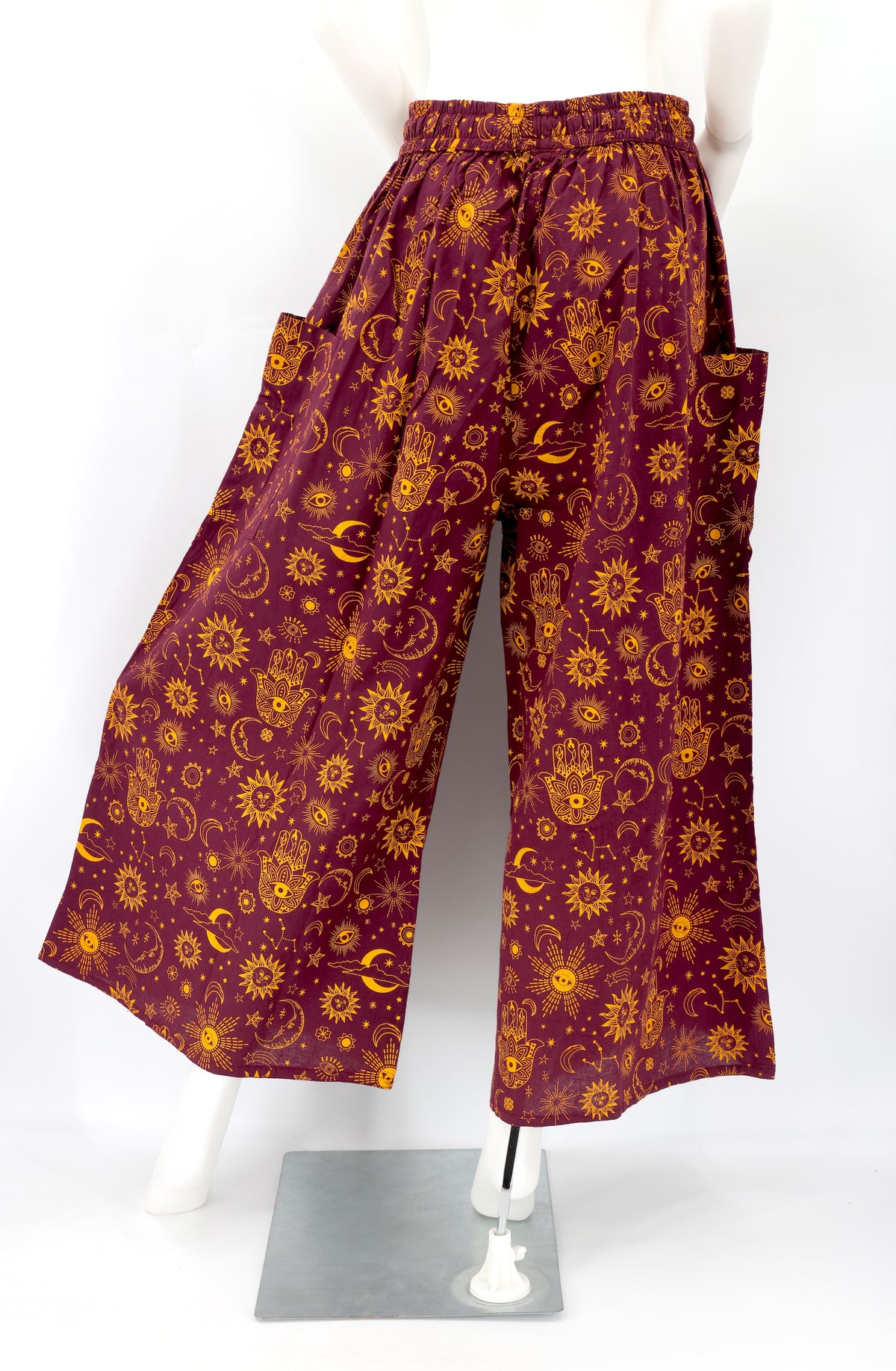 Back angle of wide-leg harem pants with celestial designs and flowy cotton fabric