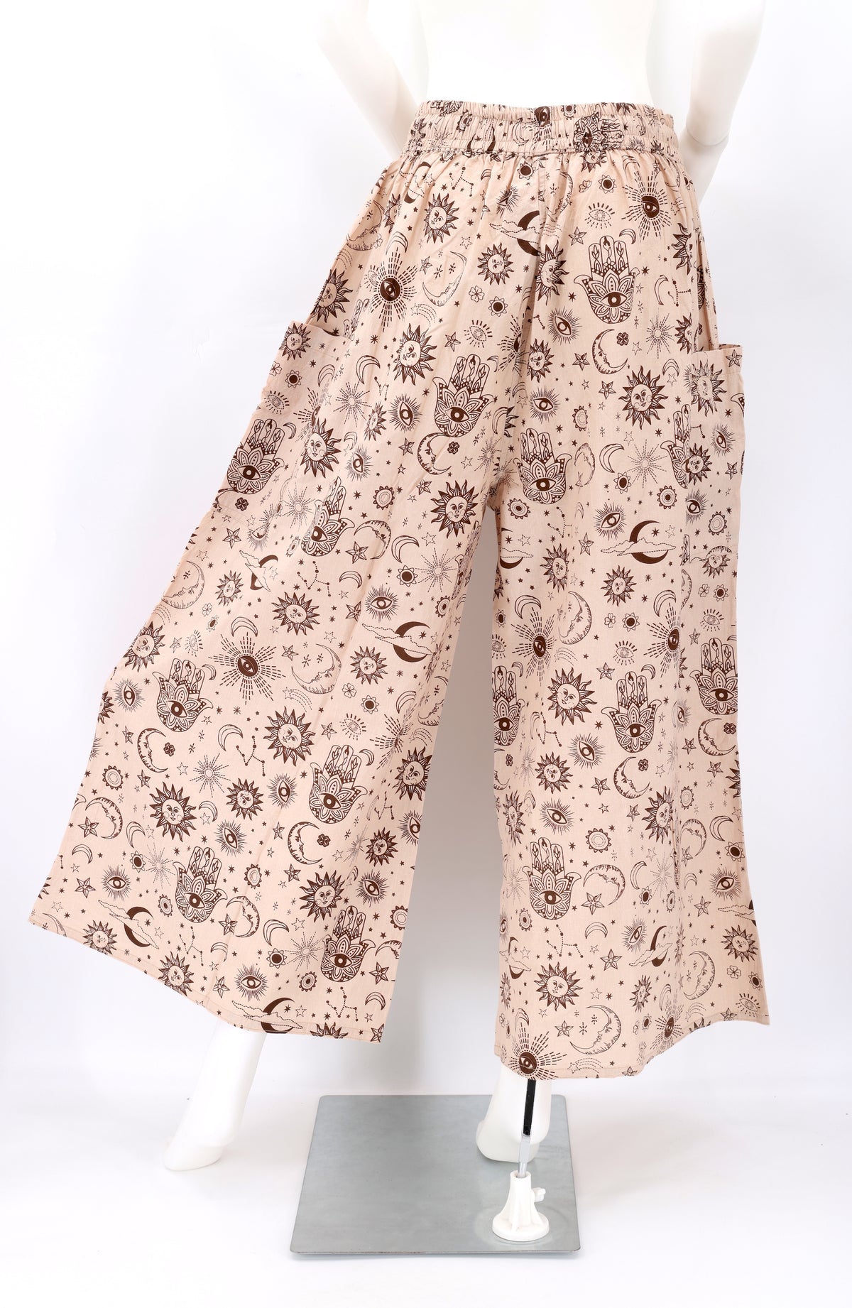 Back angle of wide-leg harem pants with celestial designs and flowy cotton fabric