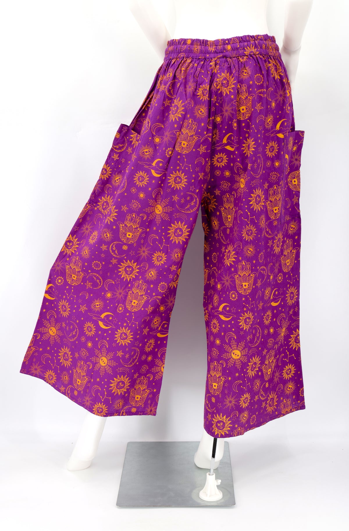 Back angle of wide-leg harem pants with celestial designs and flowy cotton fabric