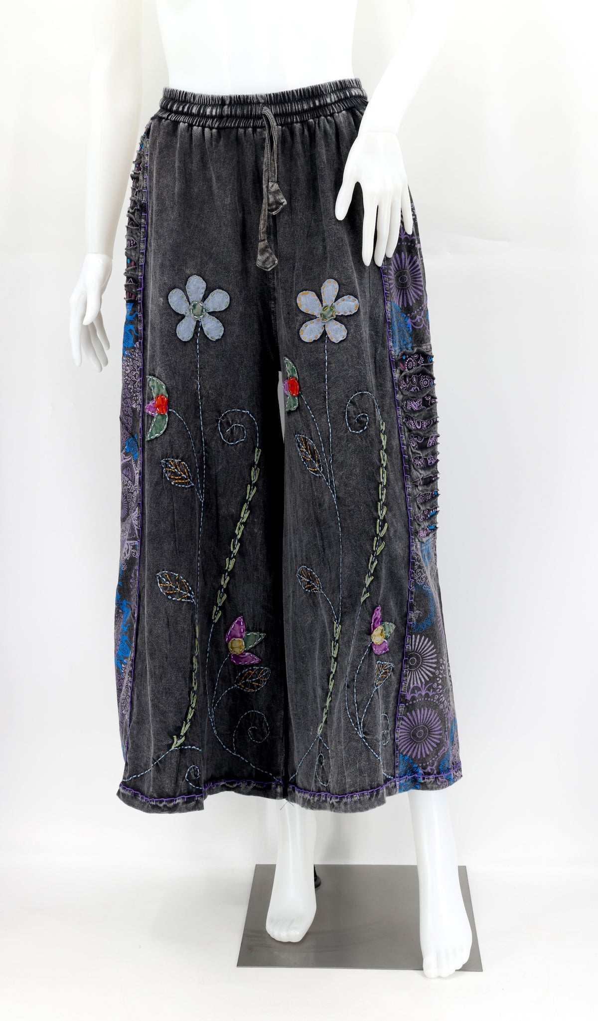 Front view of handmade floral embroidered wide-leg cotton trousers in natural tones.