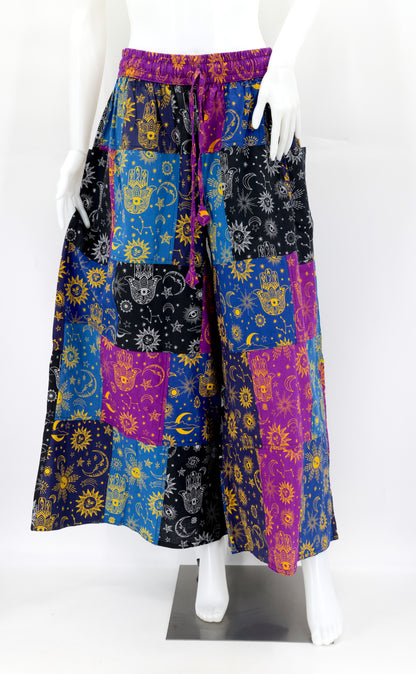 Detail of vibrant handwoven cotton patchwork with celestial motifs on bohemian harem pants