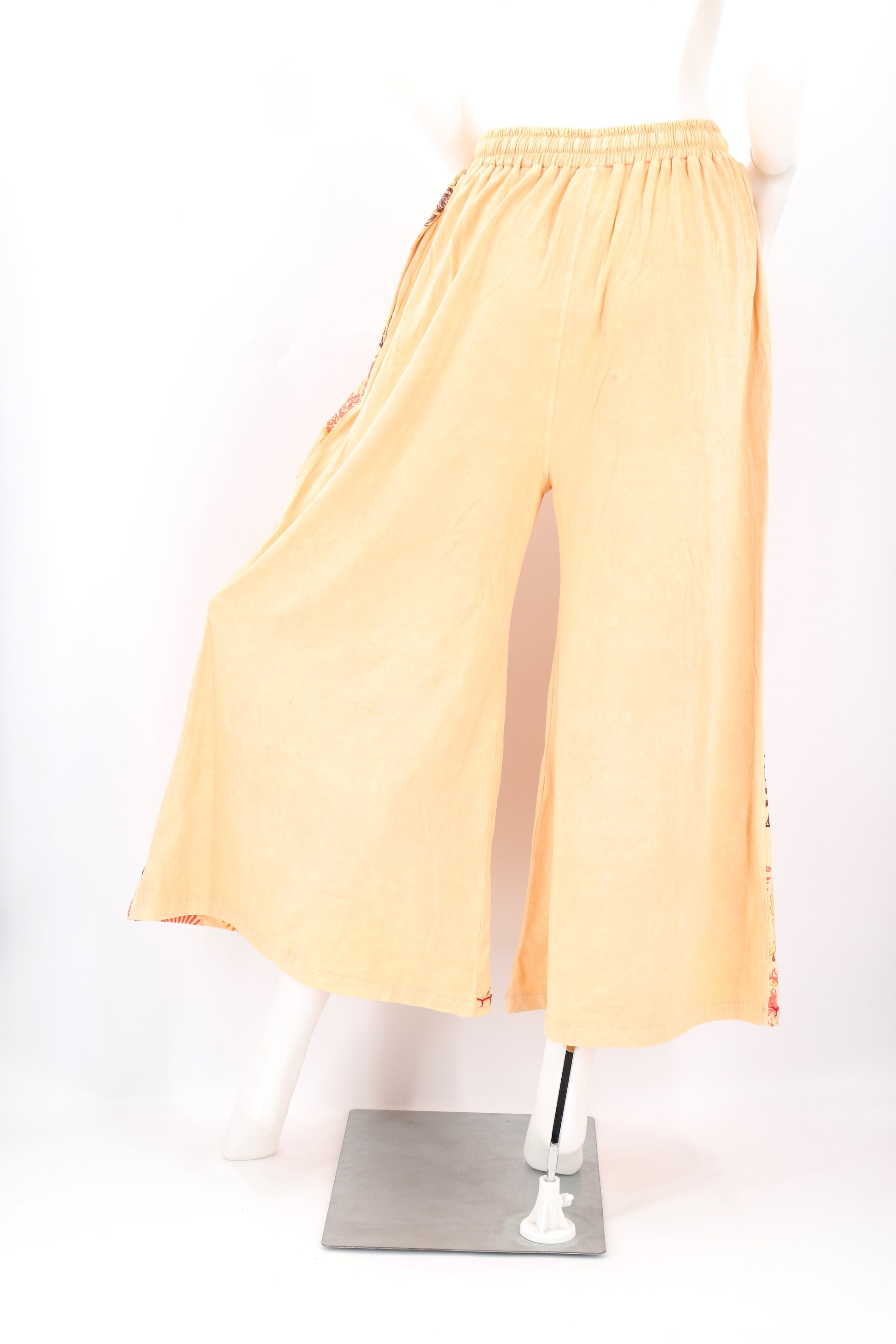 Mannequin wearing peach-colored pants on a white background - Backside